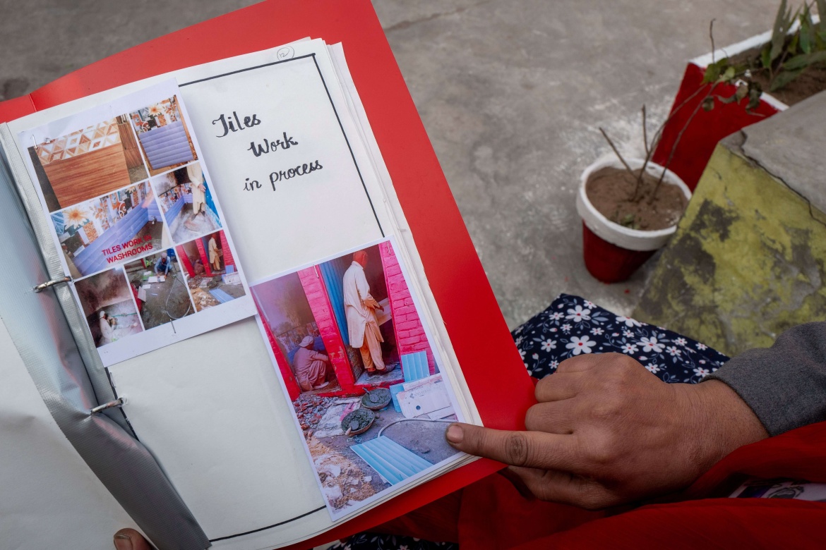 Fozia Nadeem, headteacher at the Government Primary School Junior Model Bhamma, shows before/after photos of the water and sanitation improvements at her school.